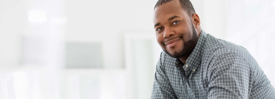 A man seated at a table, using a digital tablet