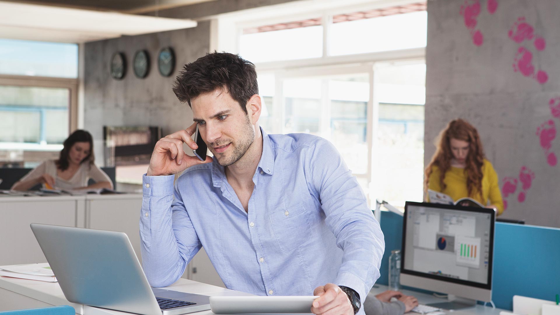 A man on call looking in his laptop
